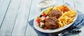 Bifteki, or Greek meat balls, with salad and chips Royalty Free Stock Photo