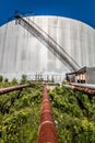 Abandoned Oil Refinery Gas Tank and Rusty Pipeline Royalty Free Stock Photo