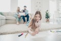 Big adopted family little girl lying floor fluffy carpet ending drawings while parents enjoy watching son`s art