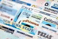 Big amount of driving licenses from various USA states. Stack of driving license specimen Royalty Free Stock Photo