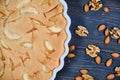 Big apple pie with nuts on dark wooden background.. Fruit cake with almonds and walnuts. Home pie ripe apples