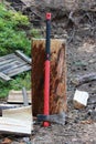 big ax with a red handle stands in the forest leaning against a wooden stump. for cooking firewood.