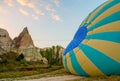 Big balloon on the ground. Preparing for the flight. A unique rocky area at dawn with pink tender clouds. Cappadocia Turkey.