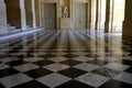 Big beautiful beige empty hallway with black and white chess tile floor in the palace of Versailles