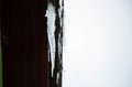 A big beautiful icicle hanging from the roof