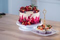 Big beautiful red velvet cake, with flowers and berries on top. Delicious sweet muffins with cream, Royalty Free Stock Photo