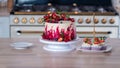 Big beautiful red velvet cake, with flowers and berries on top. Delicious sweet muffins with cream,