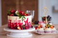 Big beautiful red velvet cake, with flowers and berries on top. Delicious sweet muffins with cream, Royalty Free Stock Photo