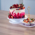 Big beautiful red velvet cake, with flowers and berries on top. Delicious sweet muffins with cream, Royalty Free Stock Photo