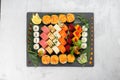 Big beautiful set of different types of sushi maki on a black rectangular stone slate plate. Royalty Free Stock Photo