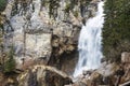 Big beautiful spring mountain waterfall deep in the pine forest, over the cliff. Royalty Free Stock Photo