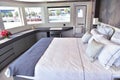 Big bed inside boat with pillows and three windows and small door