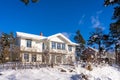 Big beige color wooden house in the countryside in winter. A typical traditional european village cottage with big panoramic windo Royalty Free Stock Photo