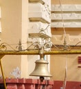 A big bell made with brass or copper hanging from a iron rod close up view. Royalty Free Stock Photo