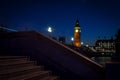 Big ben from across the river Thames, and the staircase that leads to the Westminster bridge at night in London, England, UK Royalty Free Stock Photo