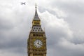 Big Ben with commercial aircraft flying overhead