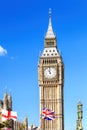 Big Ben with flag of England and United Kingdom in London against blue sky Royalty Free Stock Photo