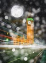 Big Ben at night with falling snow and full moon in London, UK. Royalty Free Stock Photo