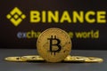 A big Bitcoin cryptocurrency coin in the centre and other bitcoin coins from both side in front of Binance crypto market . The