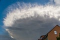 Big bizarre cloud in blue sky over roof