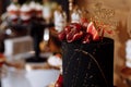 Big black birthday cake with fresh fruits and sweets on a festive table. Candy bar. Table with different sweets for party Royalty Free Stock Photo