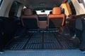 The big black empty trunk of SUV car with rubber mat and with leather folder on the floor Open luggage carrier of car closeup Royalty Free Stock Photo