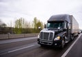 Big black modern semi truck rig trailer in traffic on highway Royalty Free Stock Photo