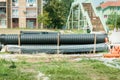 Big black and orange plastic water supply or sewerage drainage pipes prepared for pipeline reconstruction in the city district Royalty Free Stock Photo