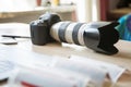 Big black photo camera with long zoom lens on table in studio Royalty Free Stock Photo