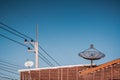 Big Black Satellite Dish on the roof with blue sky. Royalty Free Stock Photo