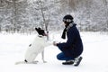 Big black-white dog is giving a paw its owner on a background of winter snowy forest Royalty Free Stock Photo