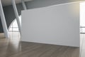 Big blank grey partition on wooden floor in modern exhibition hall with grey columns and big window. 3D rendering, mock up Royalty Free Stock Photo