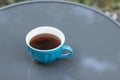 Big blue cup of hot coffee isolated on the gray table in the autumn morning garden. Top view. Royalty Free Stock Photo