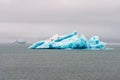 Big and blue icebergs floating around in the atlantic ocean near Greenland. Overcast sky.