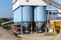 Big blue metallic Industrial silos for the production of cement at an industrial cement plant on the background of blue sky. Royalty Free Stock Photo