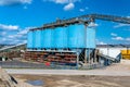 Big blue metallic Industrial silos for the production of cement at an industrial cement plant on the background of blue sky. Royalty Free Stock Photo
