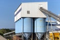 Big blue metallic Industrial silos for the production of cement at an industrial cement plant on the background of blue sky. Royalty Free Stock Photo