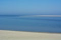 The big blue ocean with a blue sky and a long empty beach in the daylight Royalty Free Stock Photo
