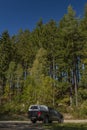 Big blue off-road car with white roof in color autumn forest in mountains Sumava