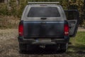 Big blue off-road car with white roof in color autumn forest in mountains Sumava