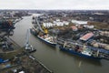 big blue ship and yellow cranes on the water in the port of an industrial city. Cargo transportation by sea. concept. top view, Royalty Free Stock Photo