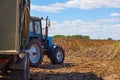 Big blue tractor with a trailer loaded with sunflower seeds close-up on the field. Royalty Free Stock Photo