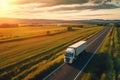 Big blue truck driving fast with a white trailer with blank space for text on a countryside road with other cars against Royalty Free Stock Photo