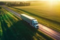 Big blue truck driving fast with a white trailer with blank space for text on a countryside road with other cars against