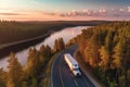 Big blue truck driving fast with a white trailer with blank space for text on a countryside road with other cars against Royalty Free Stock Photo