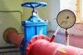 Large blue valve on the pipeline painted in red.