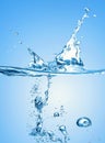 Big blue water splash on the gradient blue water background and with many air bubbles in the water Royalty Free Stock Photo