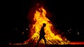 big bonfire on the beach at night with the silhouette of a kid walking around Royalty Free Stock Photo