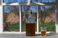 Big bottle with a drink made from fermented birch sap on the windowsill on a warm spring day, closeup. Traditional Ukrainian cold Royalty Free Stock Photo