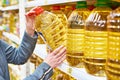 Big bottle of olive oil in hand buyer at grocery Royalty Free Stock Photo